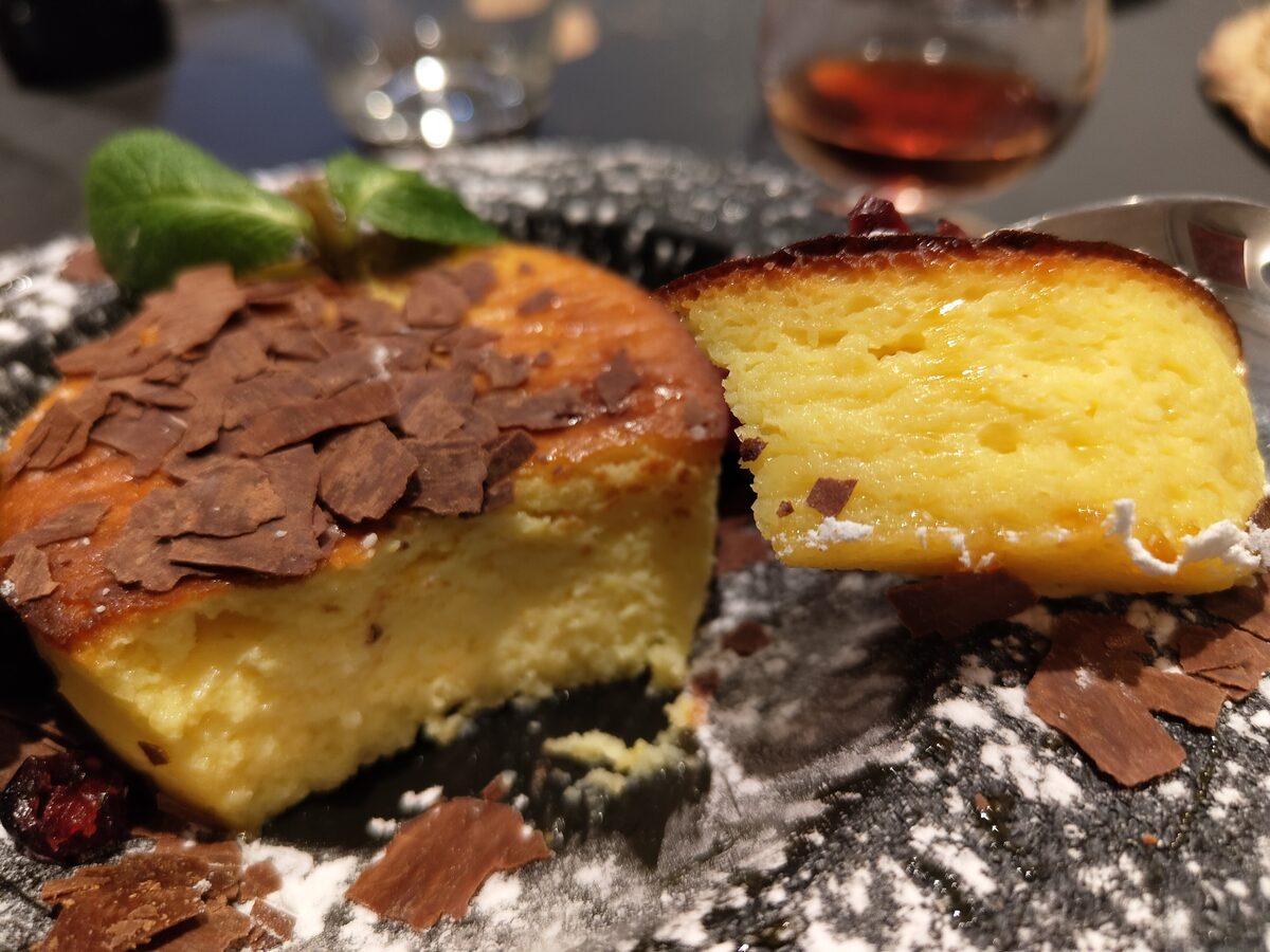 A slice of fiadone, the lemon and brocciu cake, with chocolate flakes on top