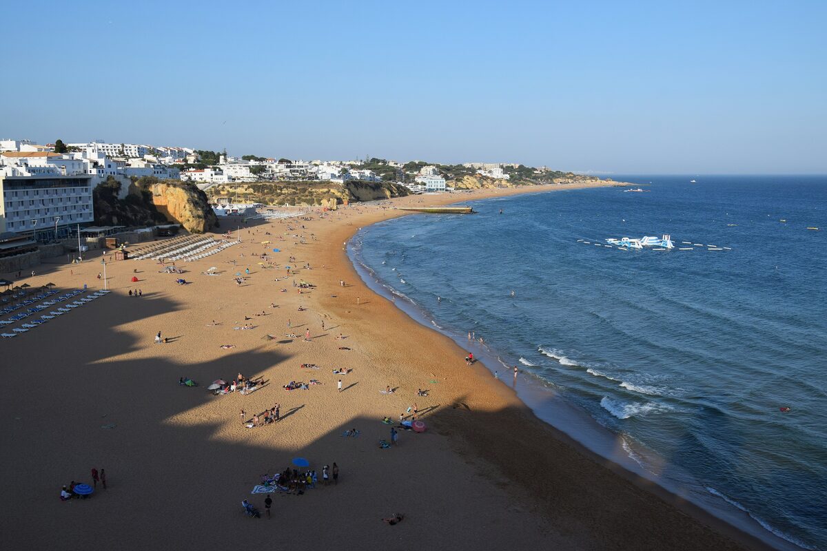 Albufeira town beach, a long sandy bay with the old town above it
