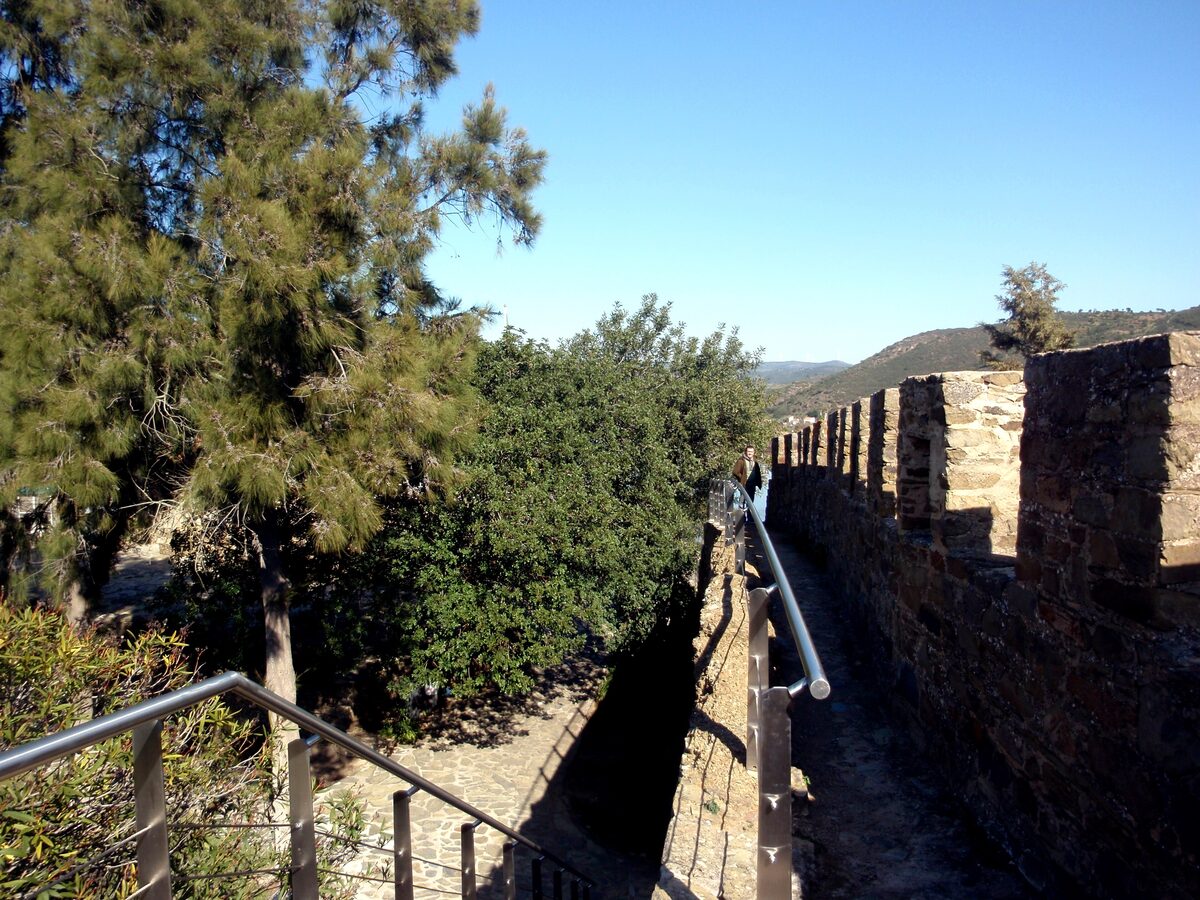 Crenellated castle walls of Alcoutim among pine trees