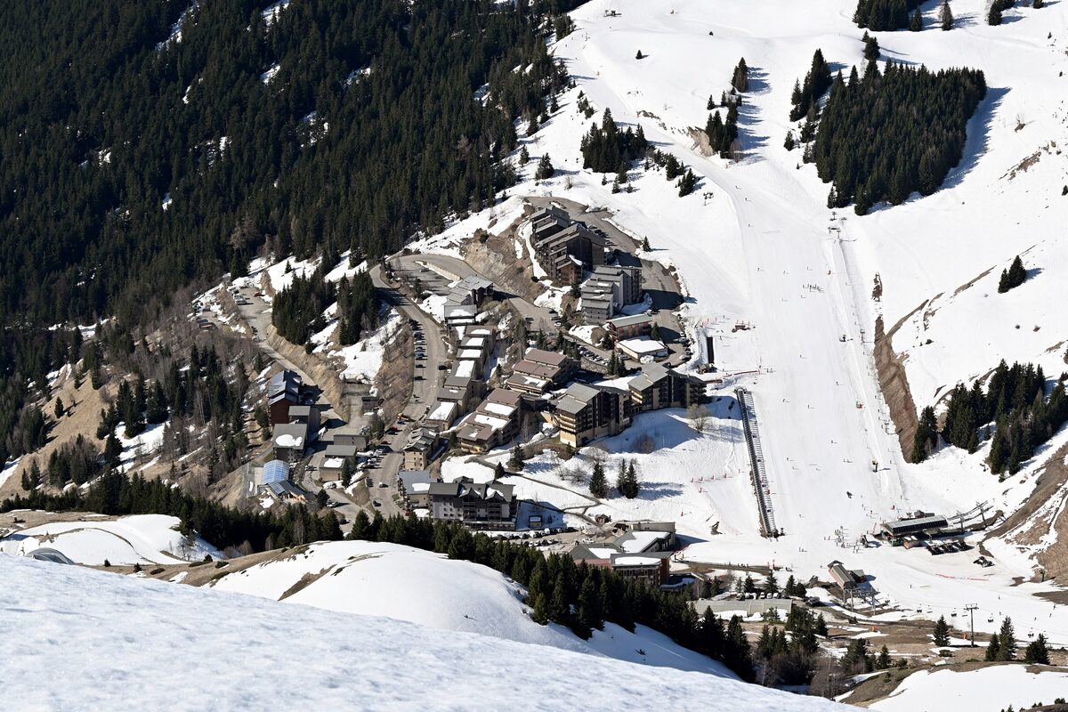 Aerial view of the Auris village in snow, with its pistes and ski runs running down the slope