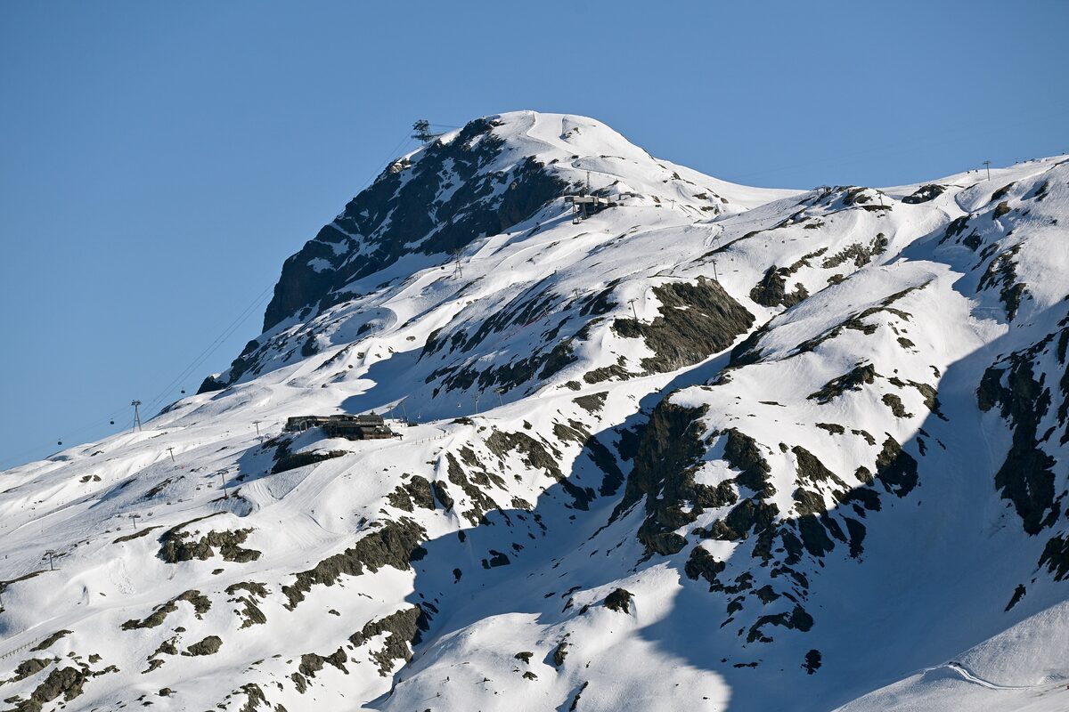The snowy Dôme des Petites Rousses seen from Signal de l'Homme, its rocky summit and steep white faces against a blue sky