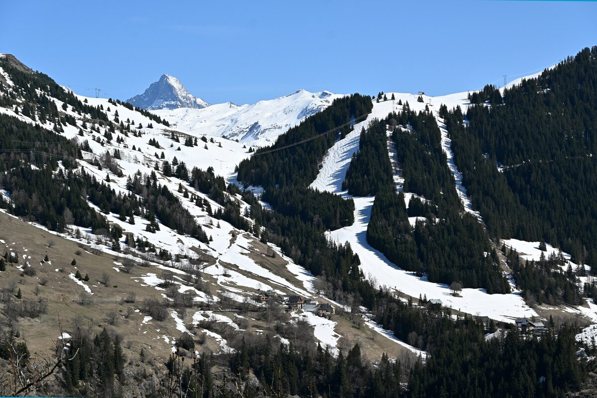 Snowy ski runs cut through the forest on the Maronne and Les Sûres slopes, with a mountain peak in the distance