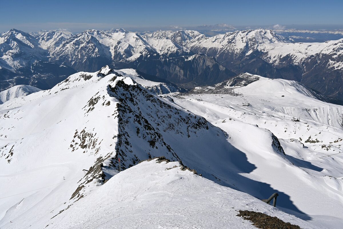 The snowy ridge of Pic Blanc looking down toward Pic de l'Herpie, with the Oisans peaks beyond