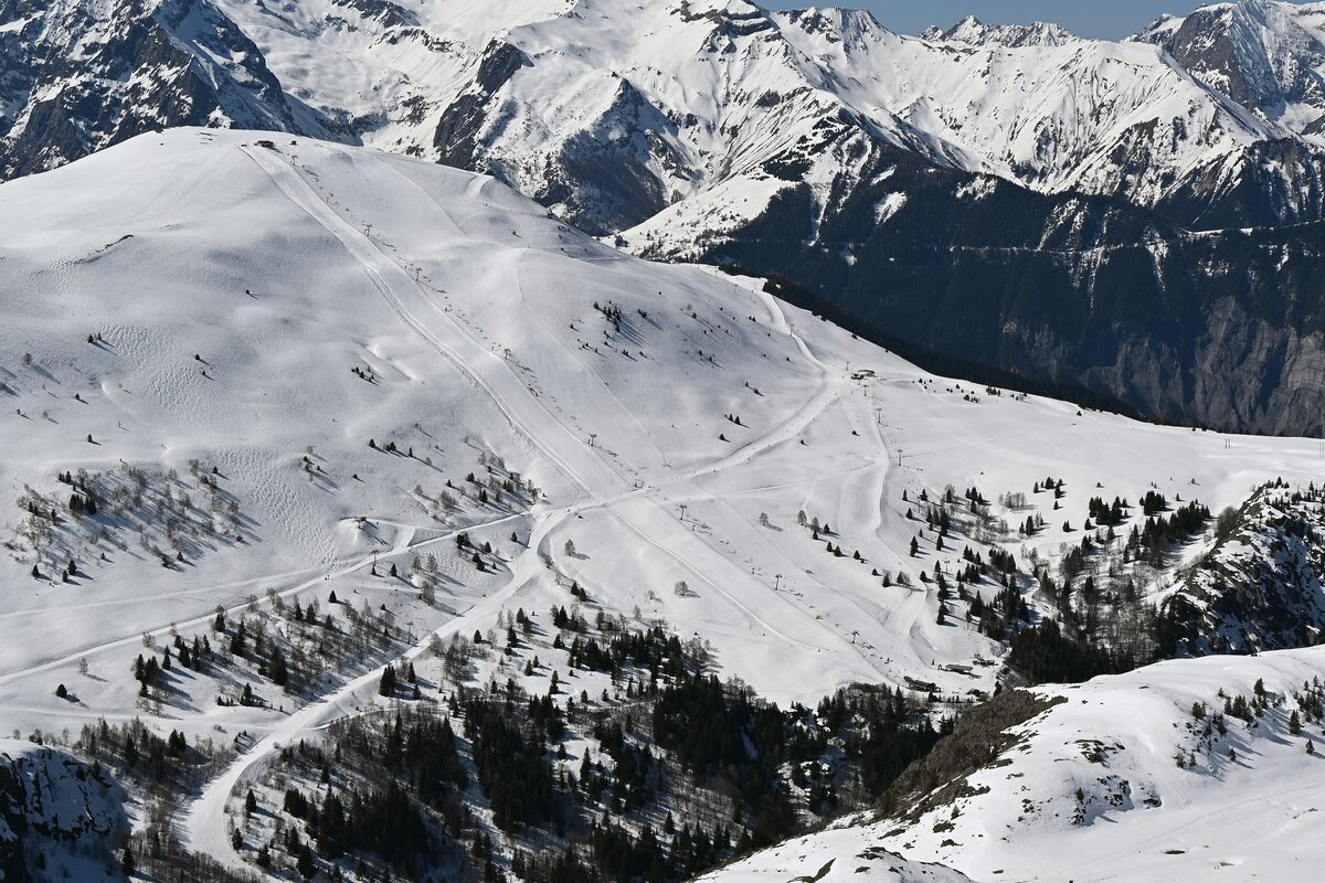 The Signal de l'Homme slopes in snow, with a long piste running down toward the Sarenne valley