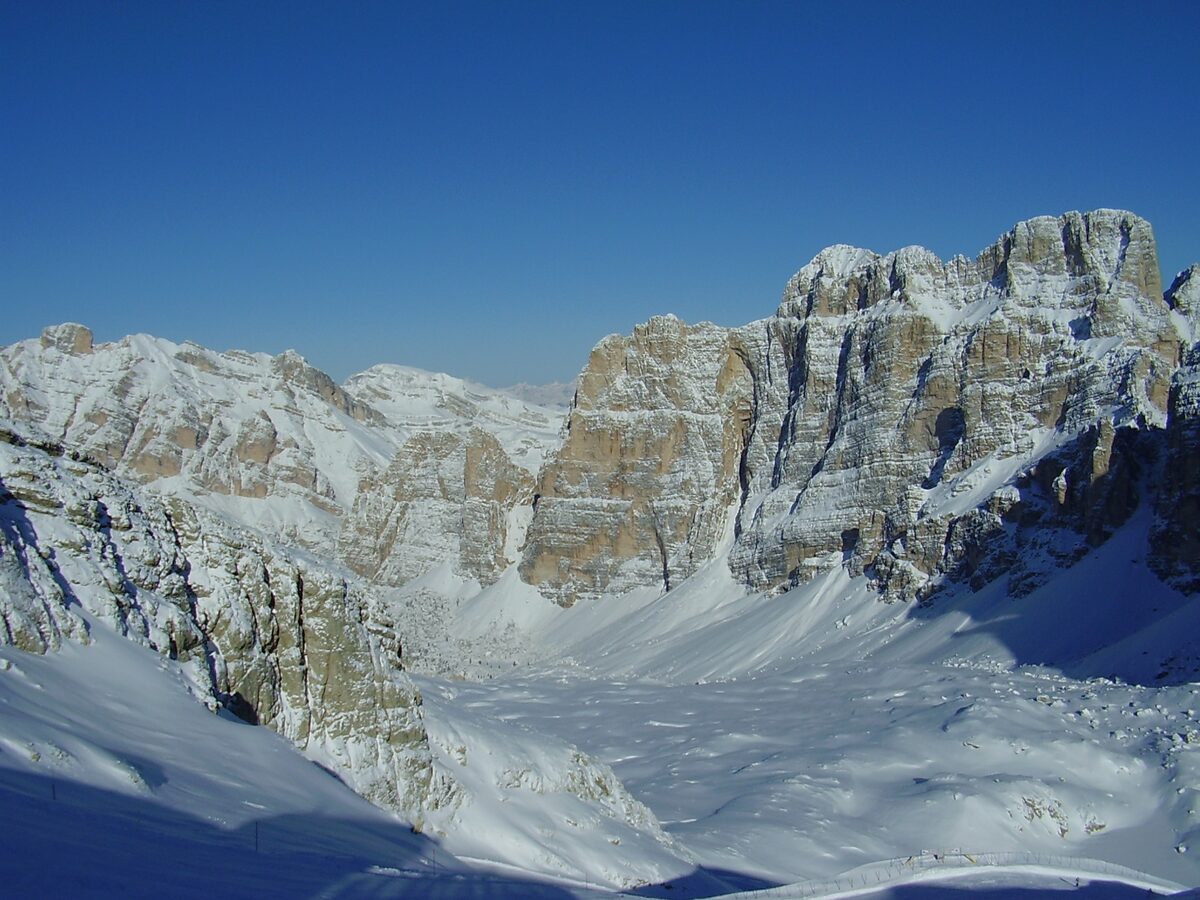 Snow-covered rock walls around an empty white basin under a deep blue sky, seen from the Lagazuoi summit area with no skiers in frame