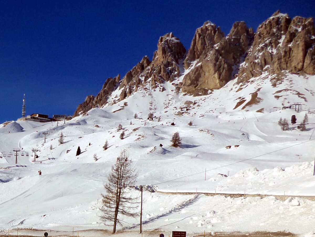 Snow-covered pistes and a lift station at Passo Gardena, with the Cir peaks rising above the pass