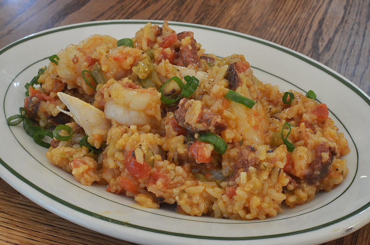 A plate of jambalaya with rice, sausage, shrimp and spring onions