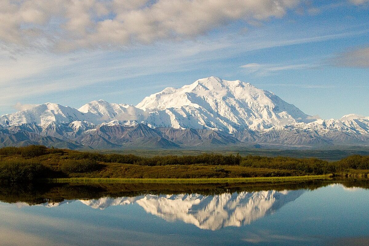 Denali and the Alaska Range reflected in a still pond near Wonder Lake on a clear summer day