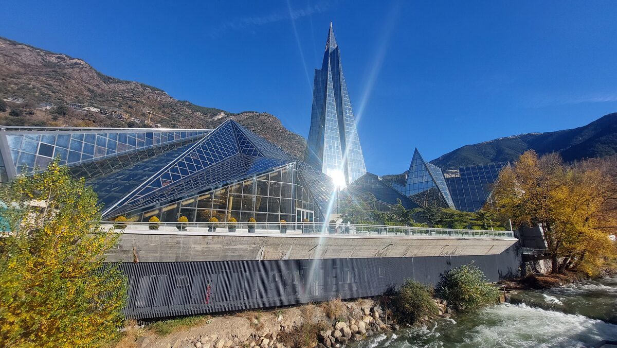 The glass and steel Caldea spa building in Escaldes-Engordany, with autumn trees in front