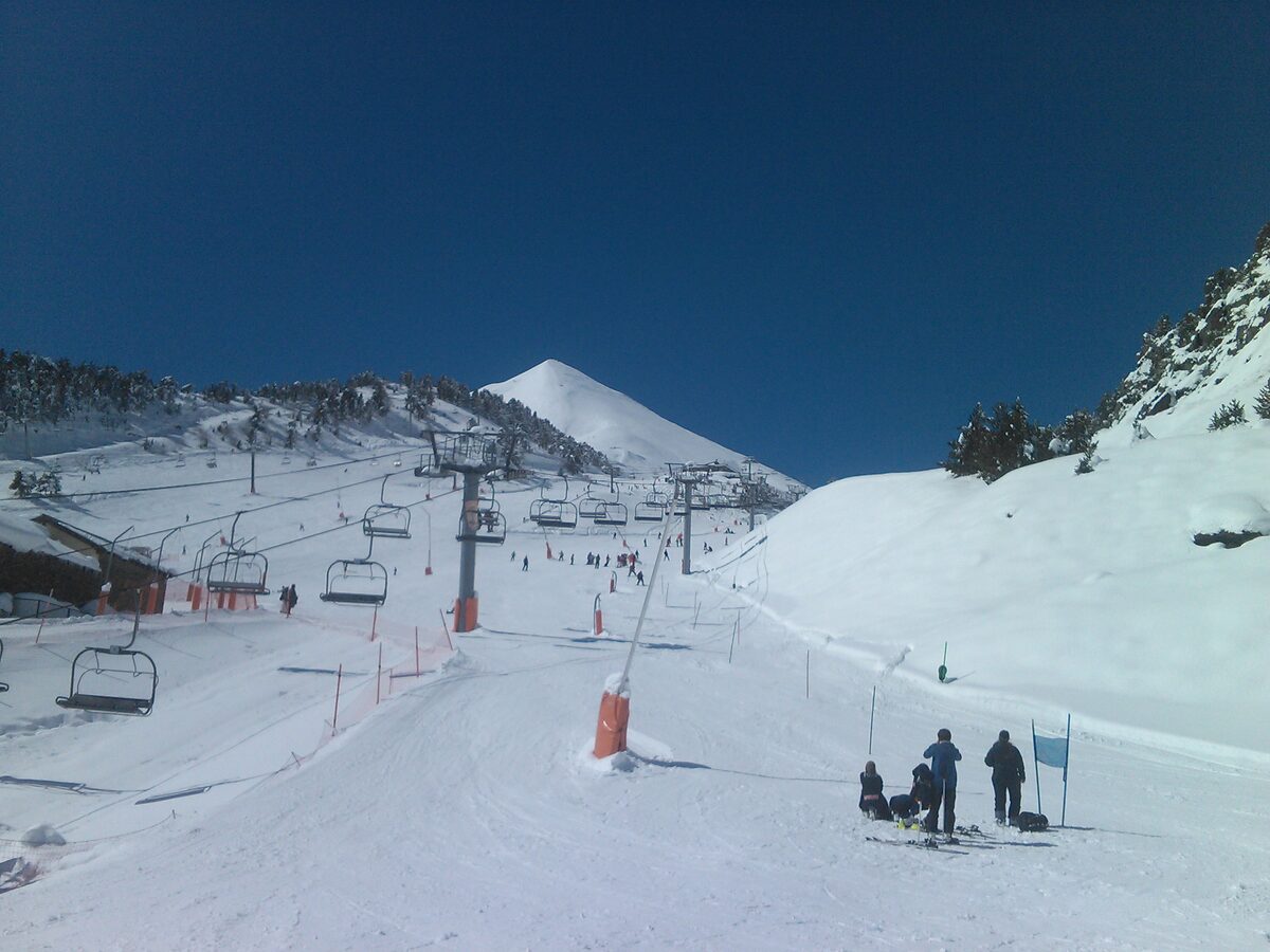 Skiers and chairlifts on the snowy Vallnord Arinsal sector, with the peak rising in the distance
