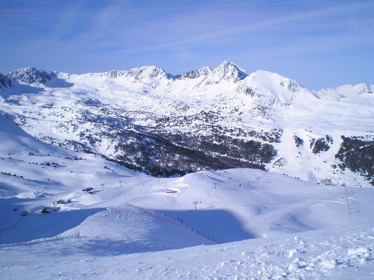 A wide snowy bowl with a lift line and rocky peaks above the Grau Roig sector of Grandvalira