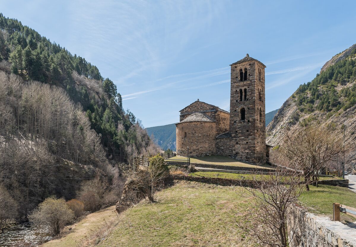 The Romanesque church of Sant Joan de Caselles with its bell tower, the trees around it still bare in spring