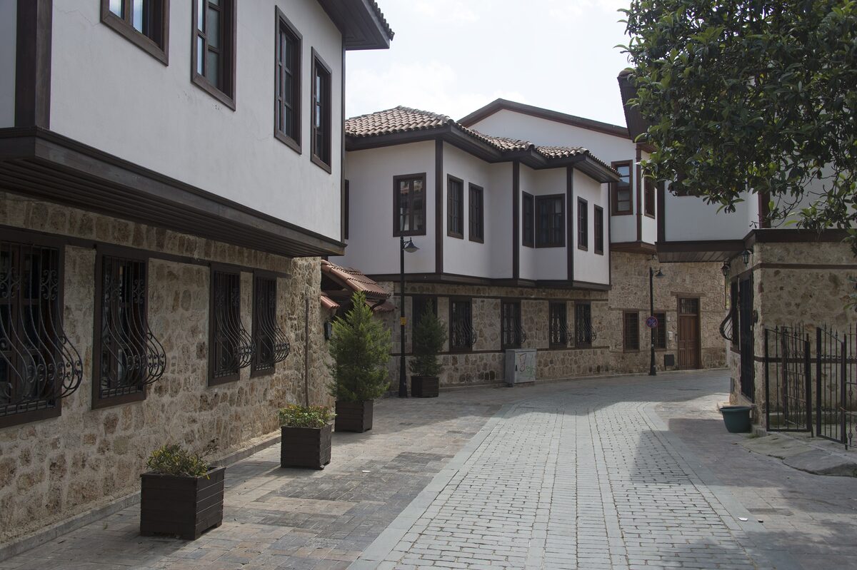 A quiet cobbled lane in Kaleiçi lined with restored white Ottoman houses with dark timber trim