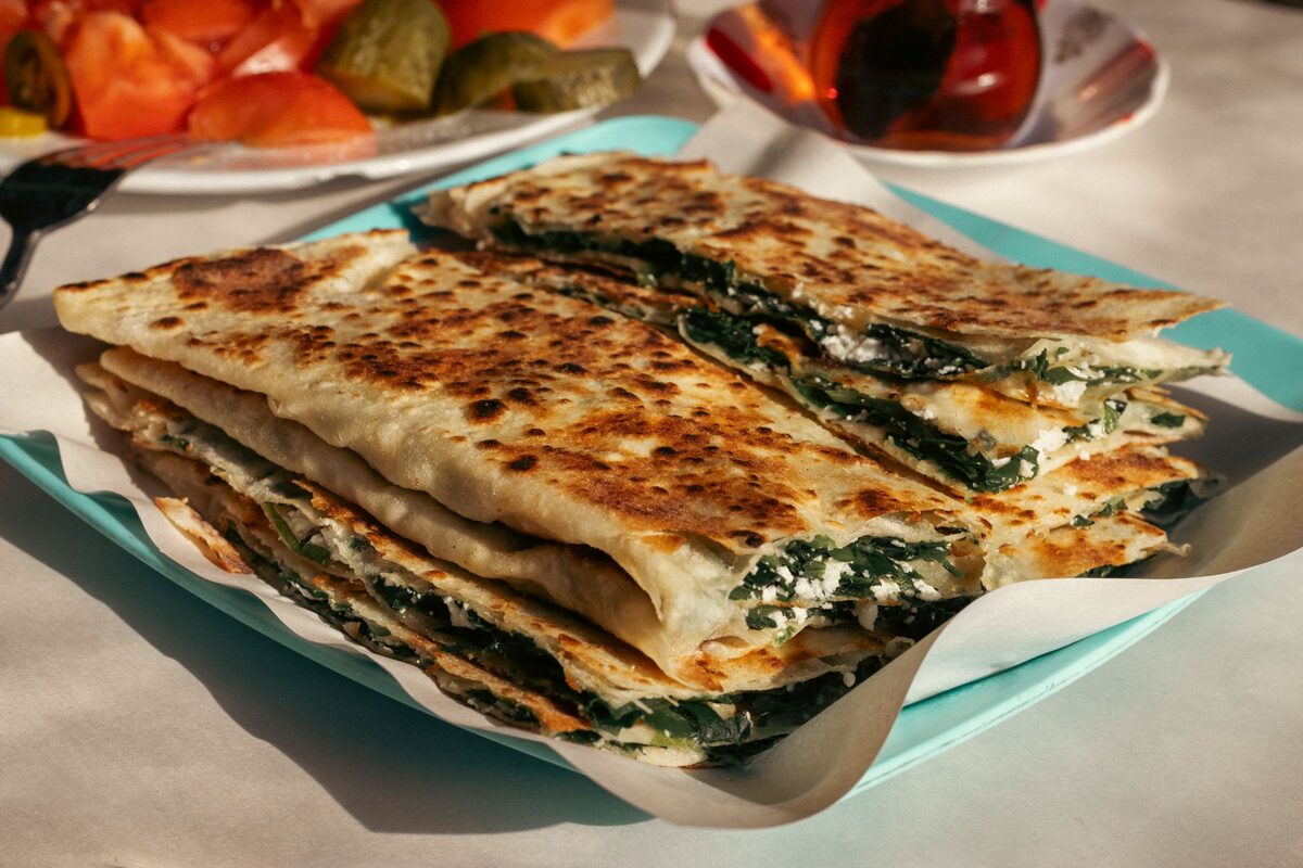 A stack of griddled gözleme filled with spinach and white cheese