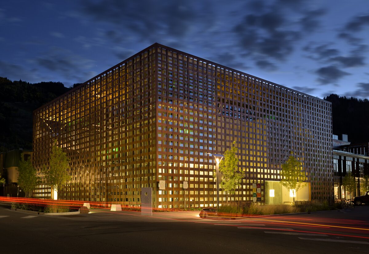 The Aspen Art Museum at dusk, a square building wrapped in a woven wooden lattice and lit from inside