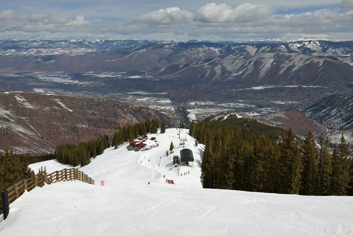 Snowy run at Aspen Highlands with a mid-mountain building and the valley far below