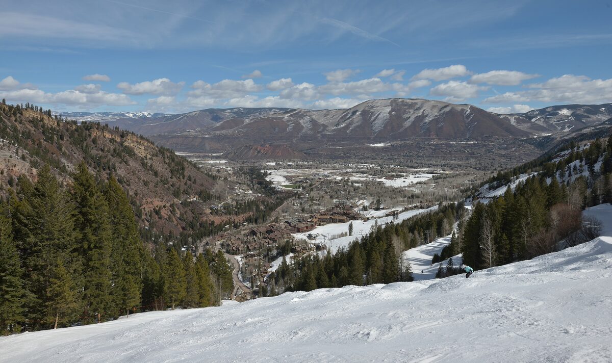 Looking down a snowy Aspen Highlands run toward the base area and the Roaring Fork valley