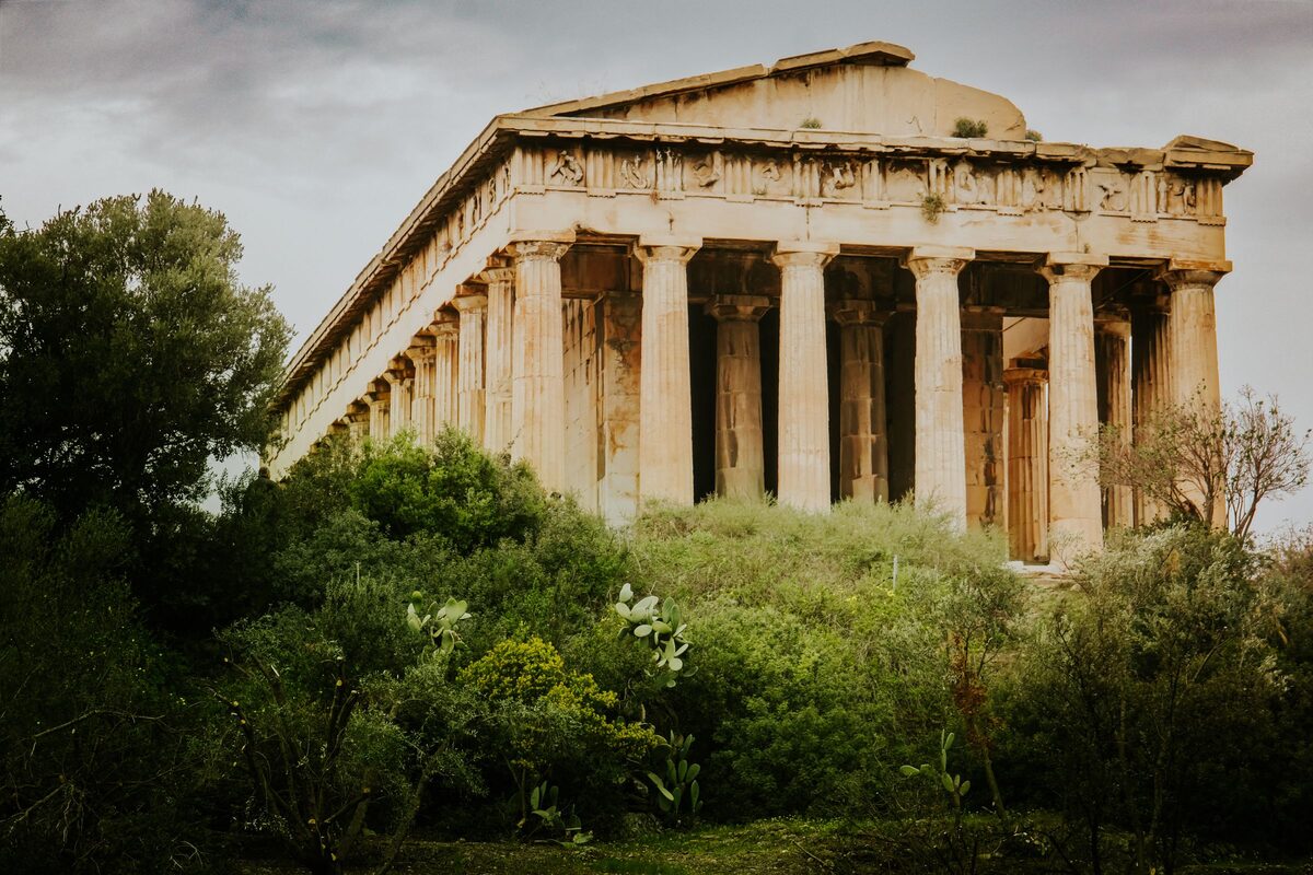 The Temple of Hephaestus rising above green shrubs in the Ancient Agora