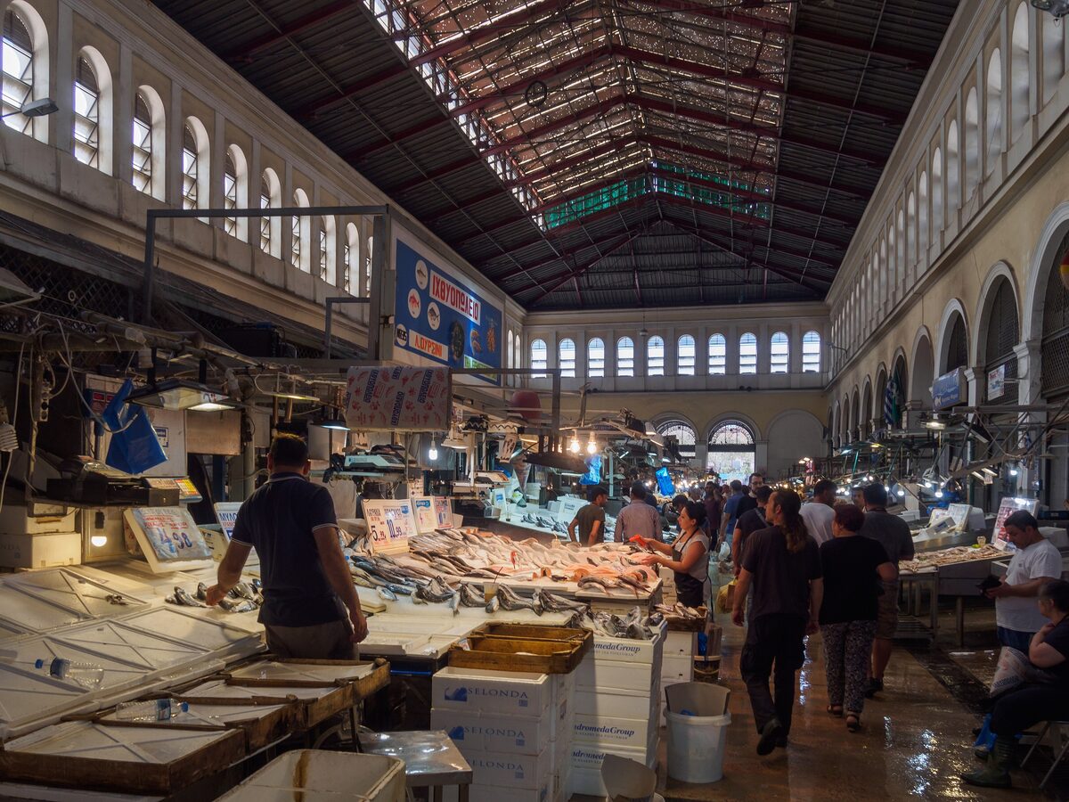The fish hall of the Varvakios market under its iron-and-glass roof, with fishmongers at ice-covered stalls