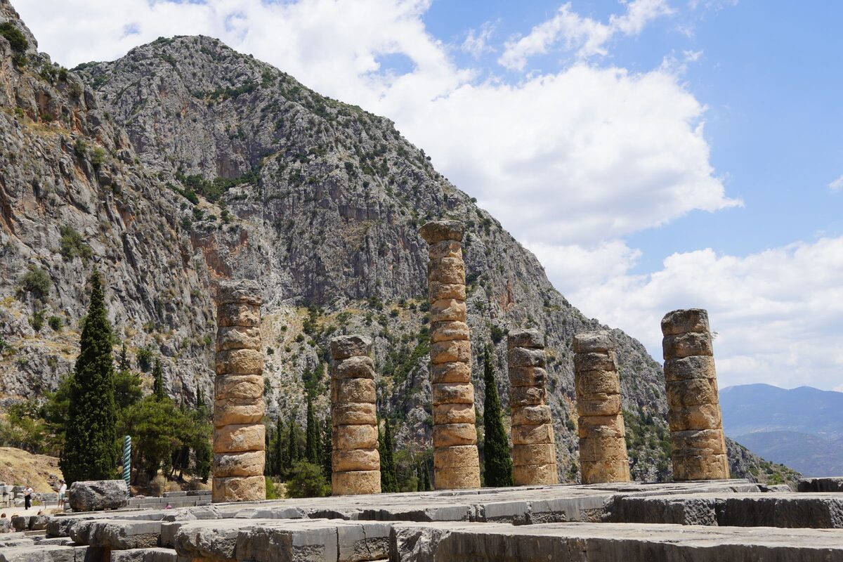 The standing columns of the Temple of Apollo at Delphi under the grey cliffs of Mount Parnassus