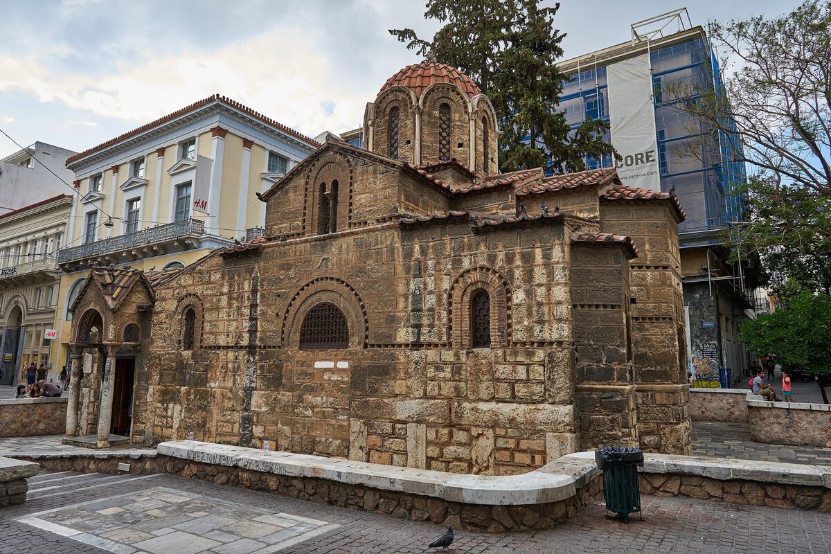 The 11th-century Byzantine church of Kapnikarea, stone and brick with a tiled dome, in its sunken square on Ermou