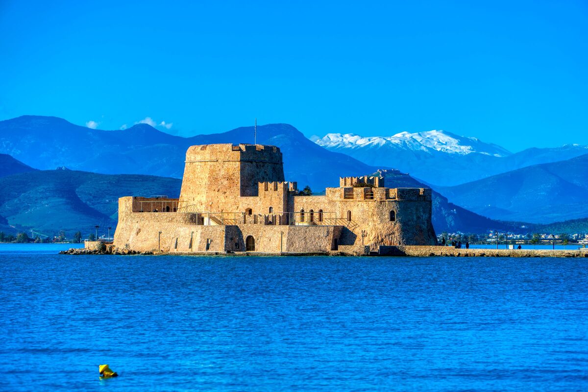 The Venetian Bourtzi fortress on its islet in the blue bay of Nafplio, with mountains behind