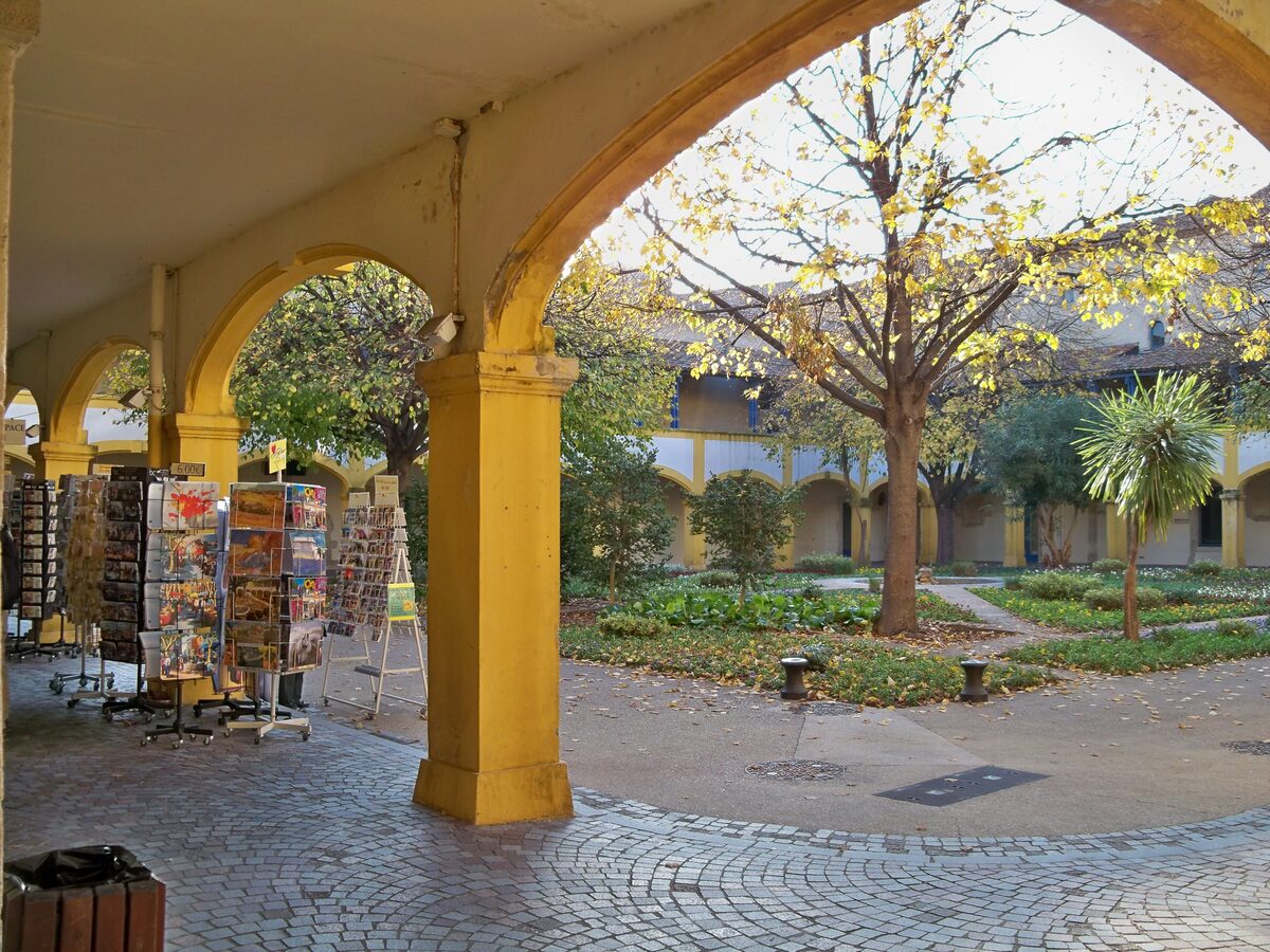 The yellow arcade and courtyard of the Espace Van Gogh, in the old Hôtel-Dieu buildings in Arles
