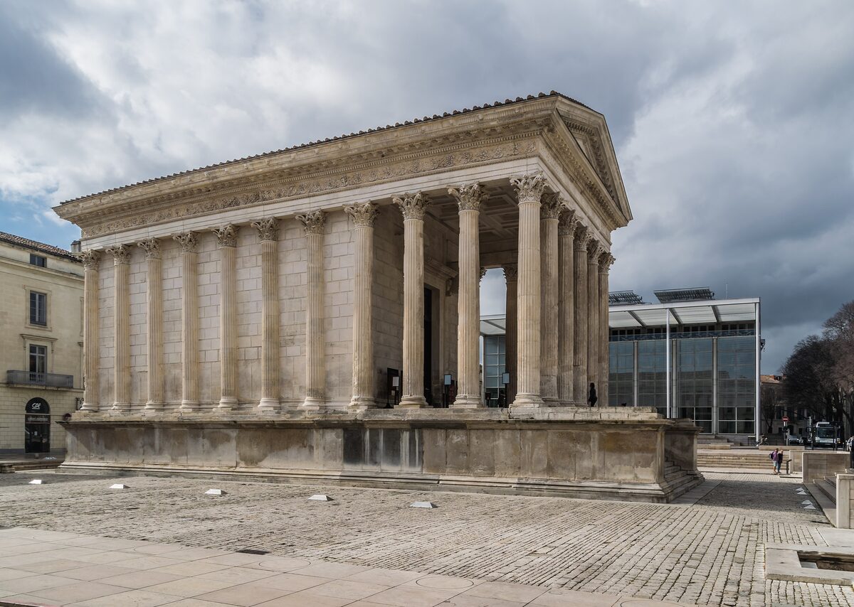 The Maison Carrée temple in Nîmes, with its row of Corinthian columns and a cloudy sky above