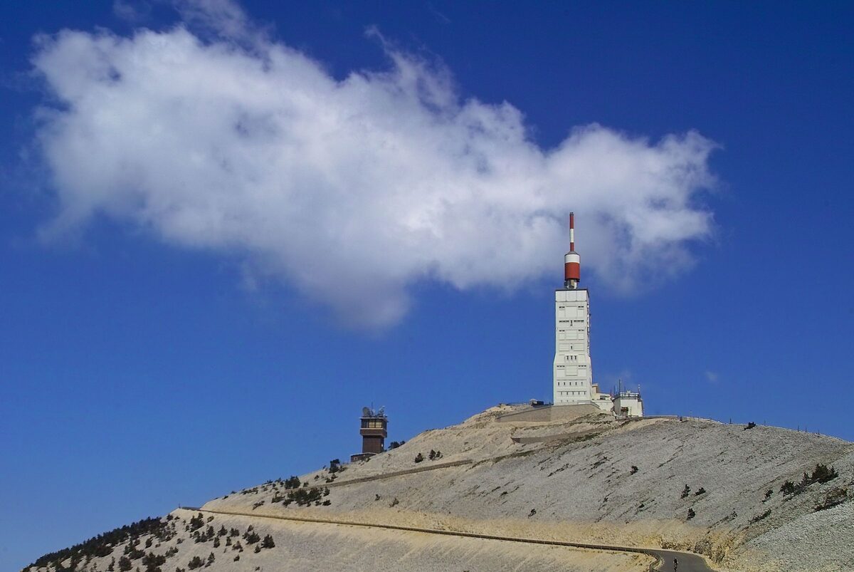 The white limestone summit of Mont Ventoux with its red-and-white tower and observatory under a deep blue sky