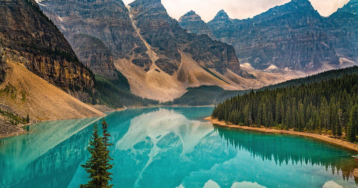 Turquoise Moraine Lake below the Ten Peaks, a hiker on a rock