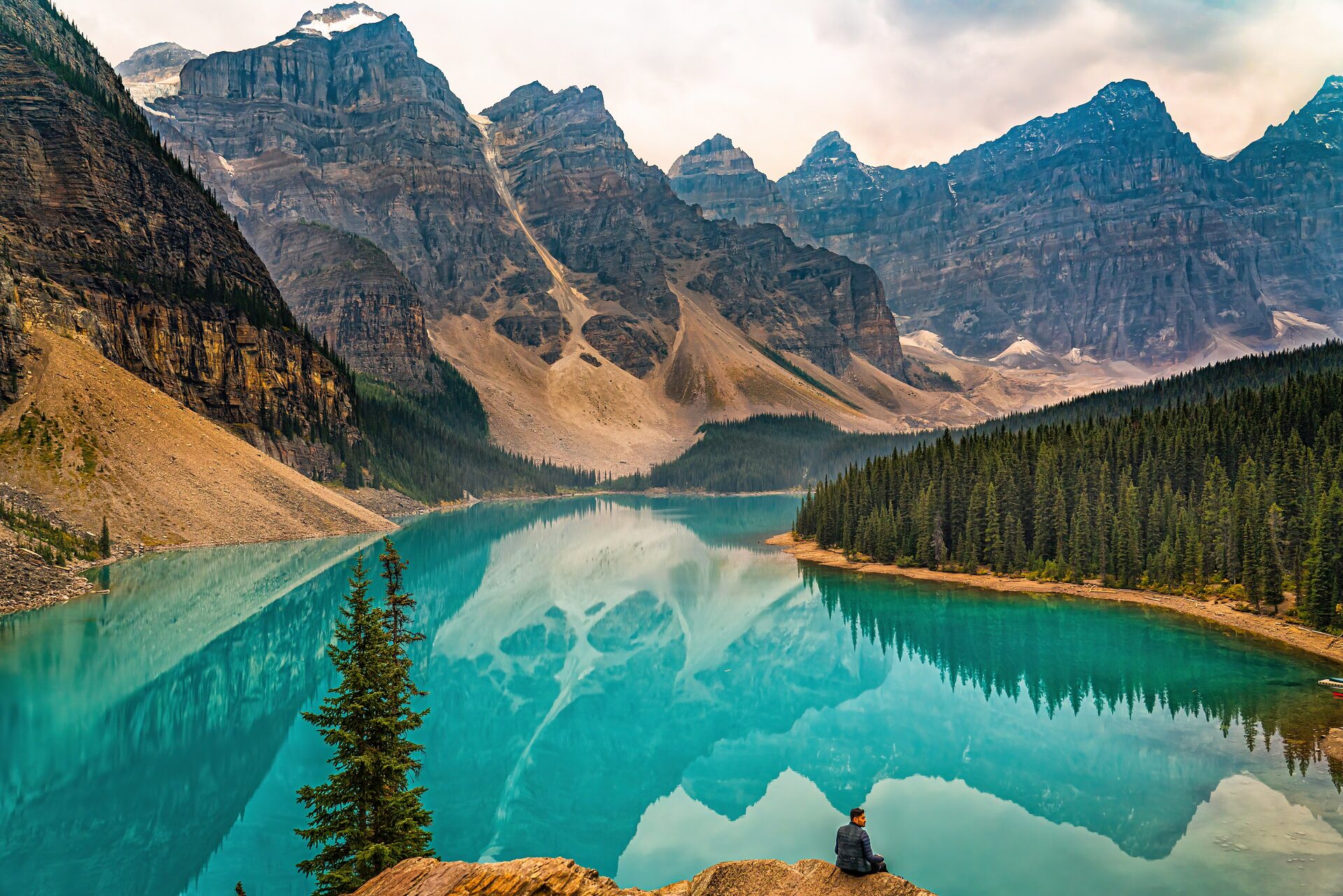 Turquoise Moraine Lake below the Ten Peaks, a hiker on a rock