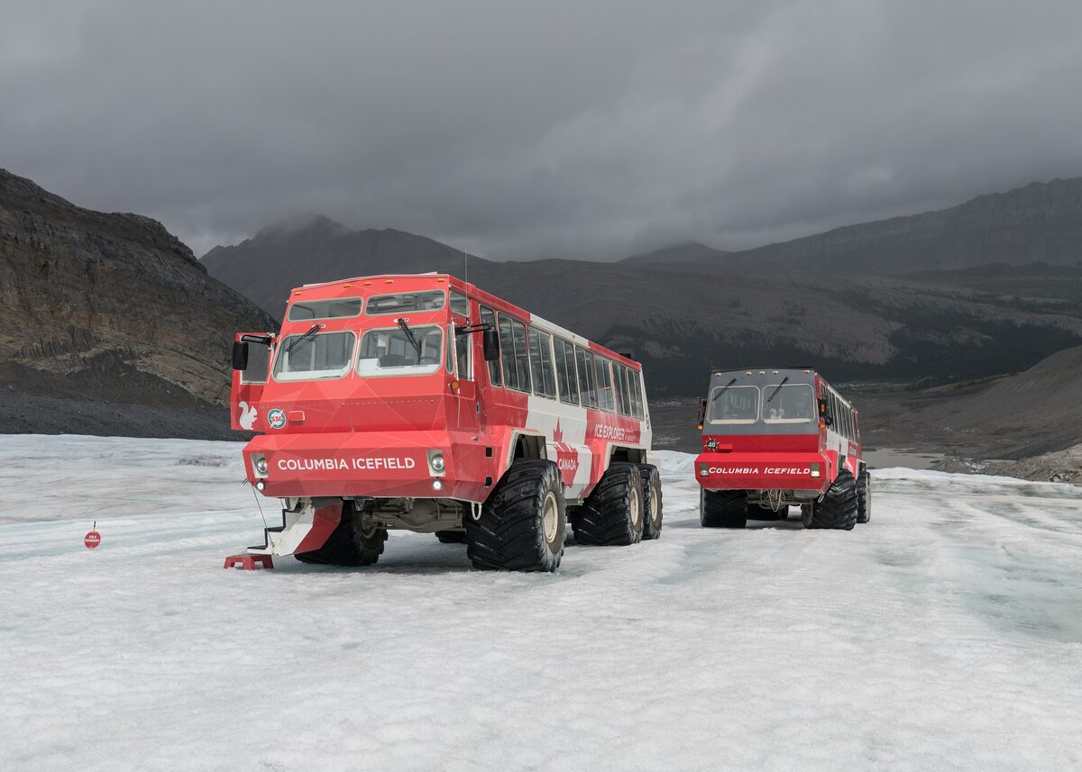 Two red Ice Explorer coaches parked on the Athabasca Glacier ice