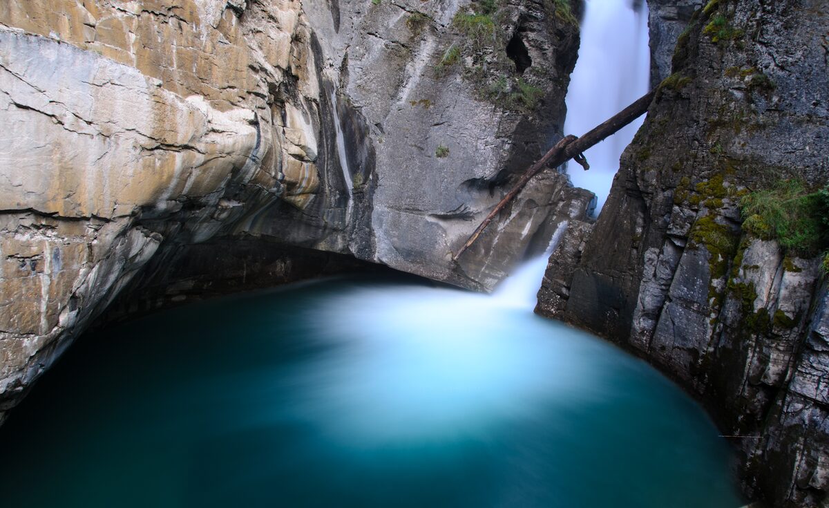 Lower Falls in Johnston Canyon pouring into a deep turquoise pool