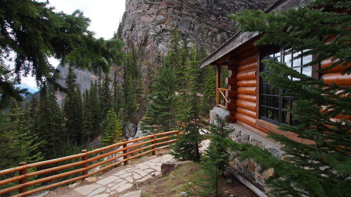 The log Lake Agnes Tea House with its terrace and cliffs behind