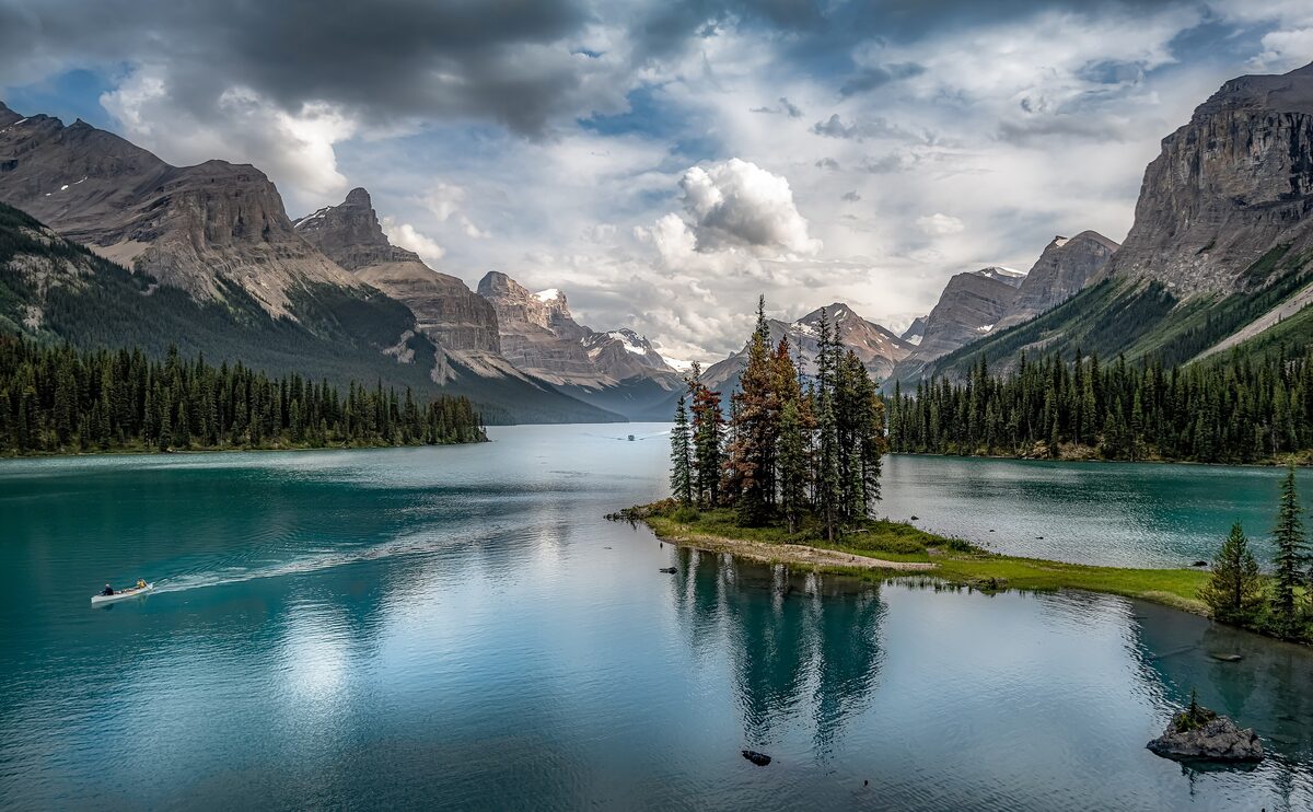 Spirit Island's spruce-covered islet in Maligne Lake with a boat wake