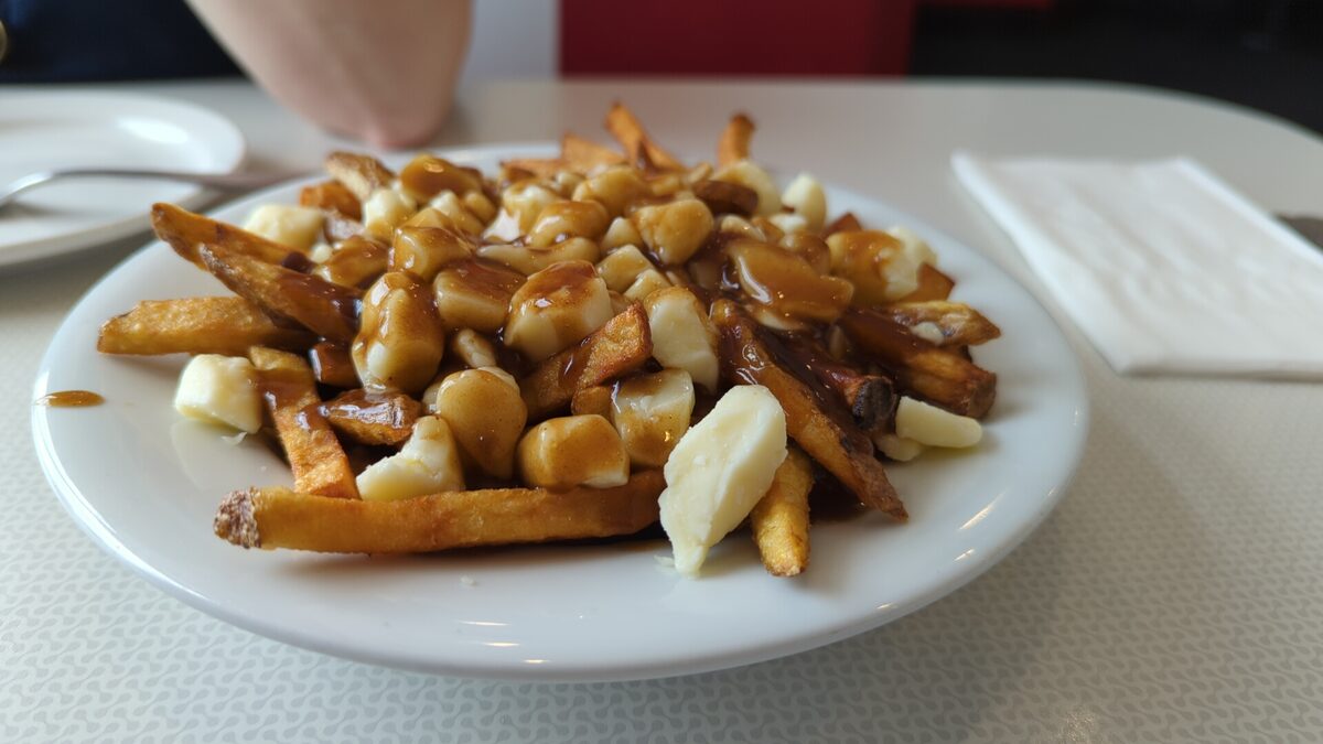 A plate of poutine: chips with brown gravy and white cheese curds