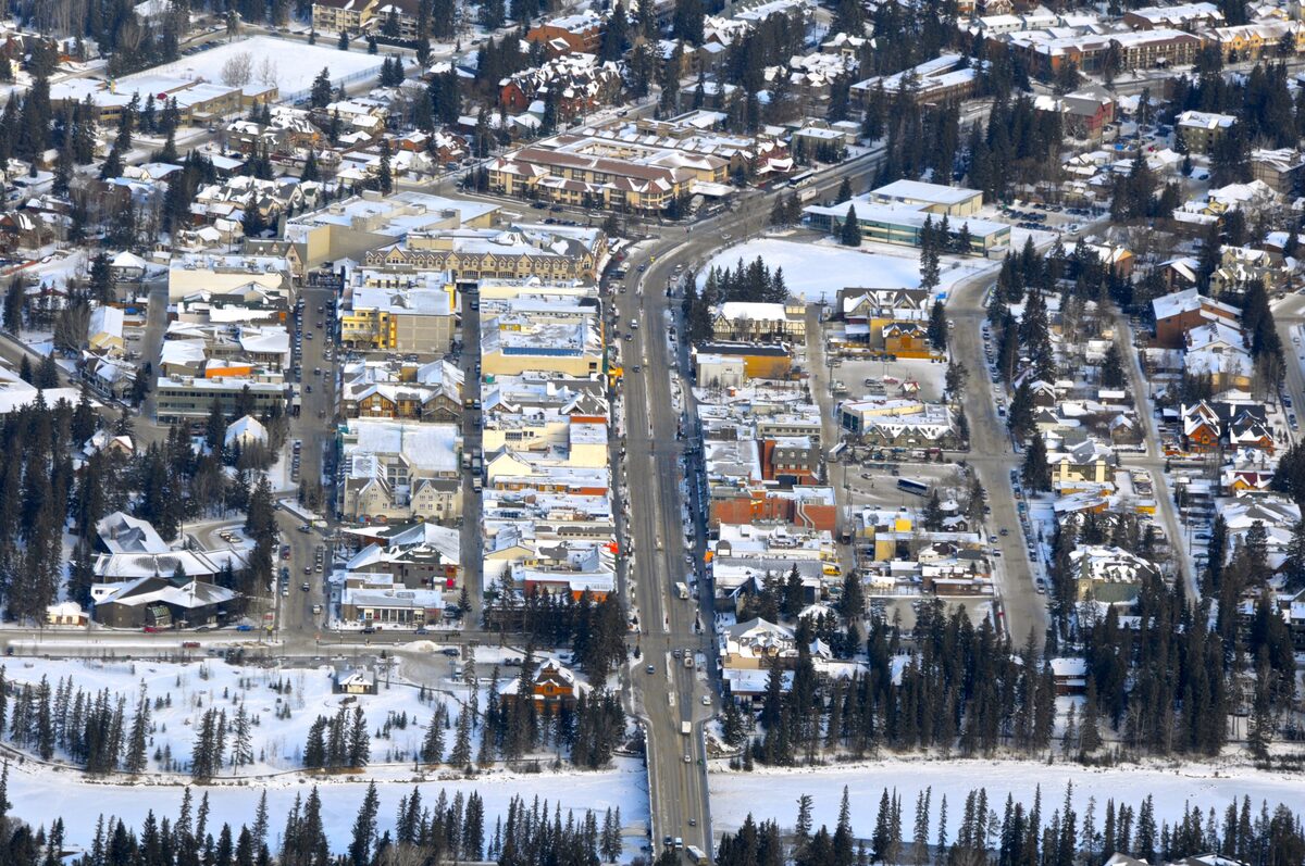 Aerial view of Banff town in winter, snow on the rooftops and Banff Avenue running straight through the grid