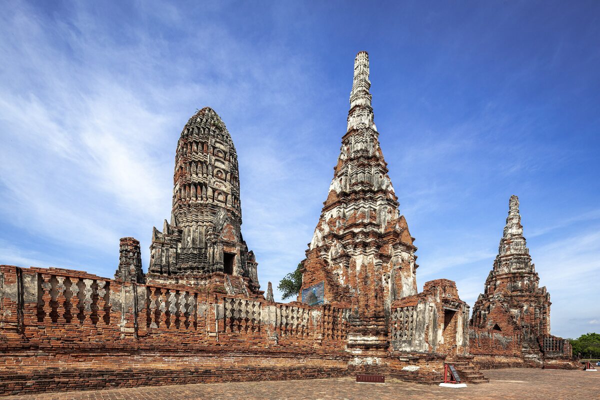 The ruined brick prangs of Wat Chaiwatthanaram in Ayutthaya under a blue sky