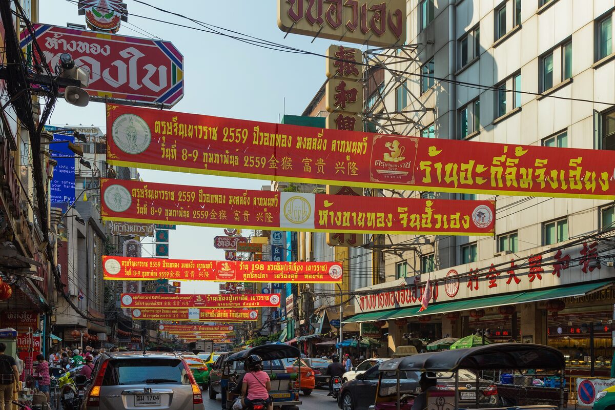 Yaowarat Road, the main street of Chinatown, with red Chinese-script signs strung over the traffic