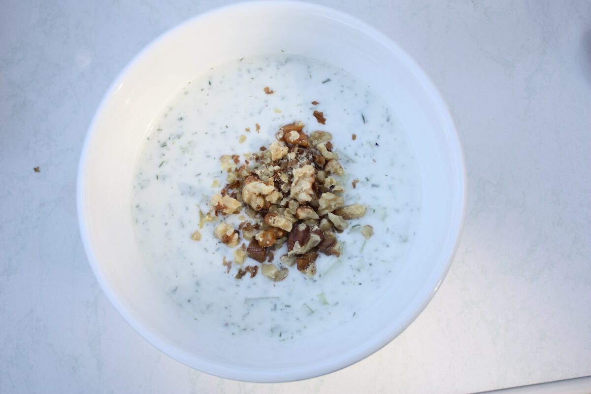 A bowl of tarator, the cold yogurt and cucumber soup topped with chopped walnuts