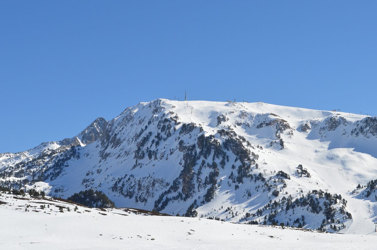 The snow-covered summit ridge of Cap de Vaquèira under a clear blue sky
