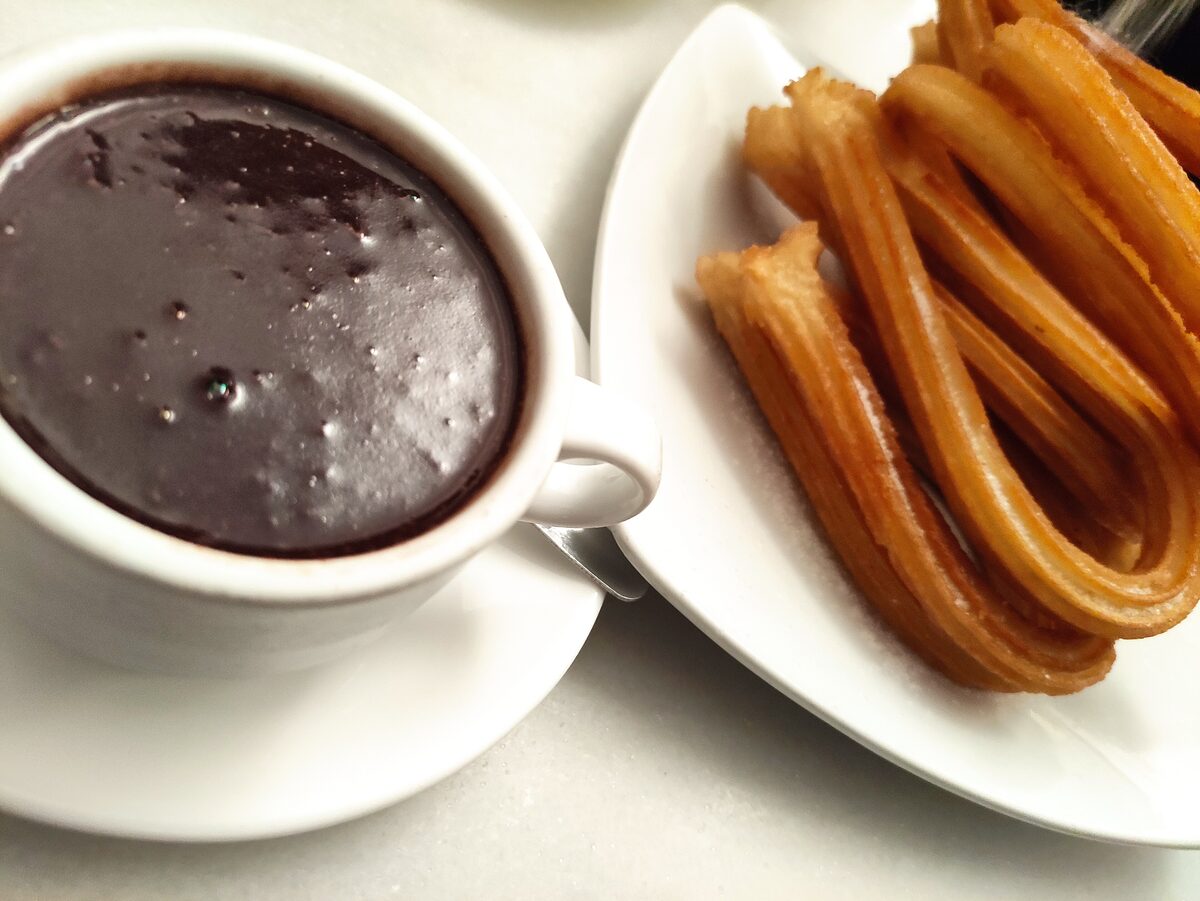 Churros beside a cup of thick hot chocolate