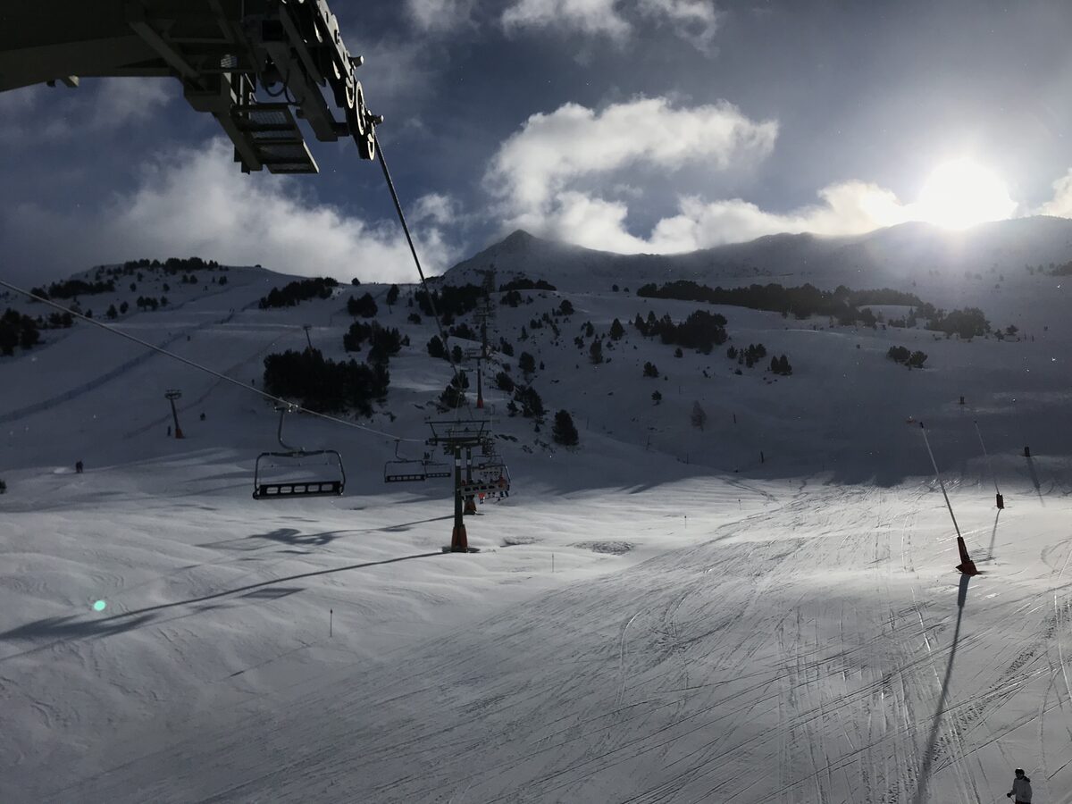 A chairlift over a groomed piste in low sun at Baqueira Beret