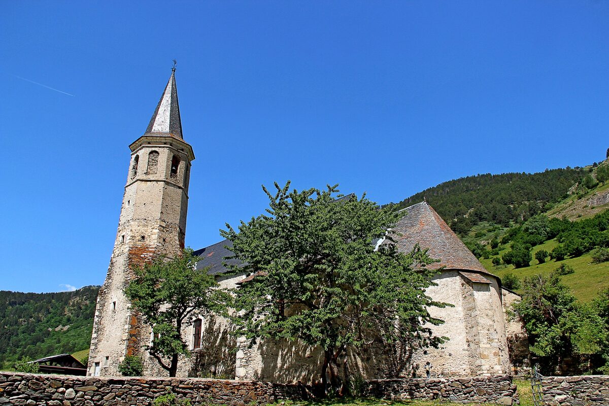 The Santuari de Montgarri, a stone church with a tall bell tower in a green valley