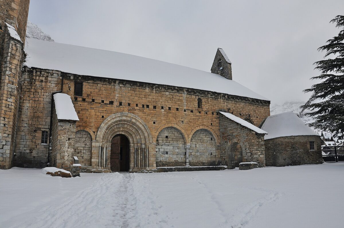 The Romanesque church of Sant Andreu in Salardú, its stone walls and portal under snow