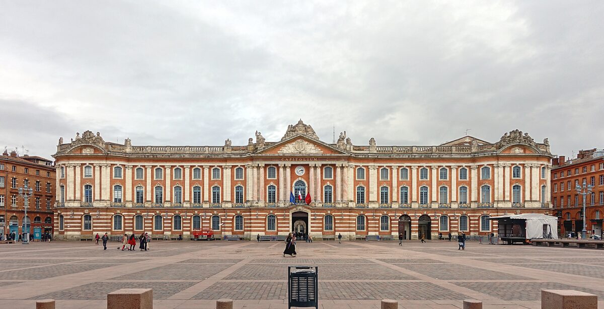 The brick and stone façade of the Capitole on its large square in Toulouse