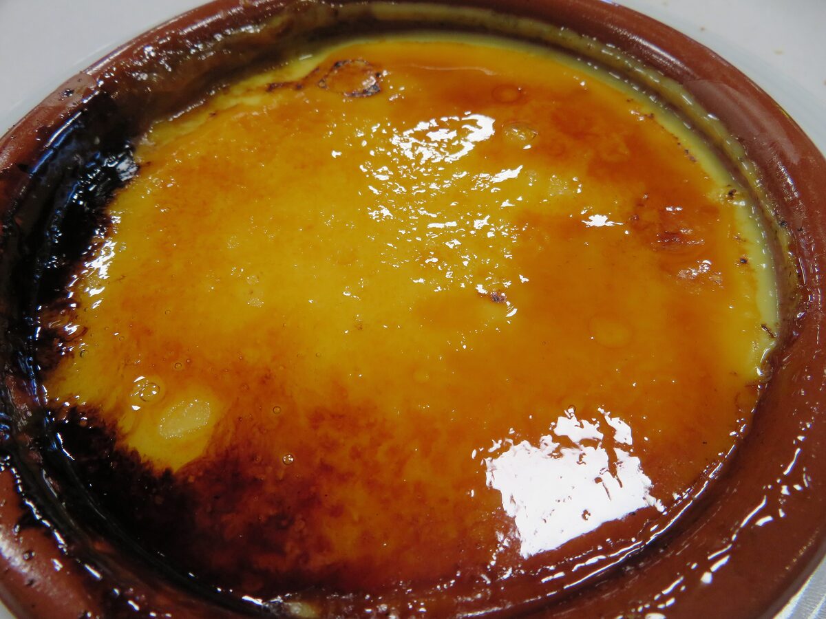 A crema catalana with its burnt sugar crust in a clay dish