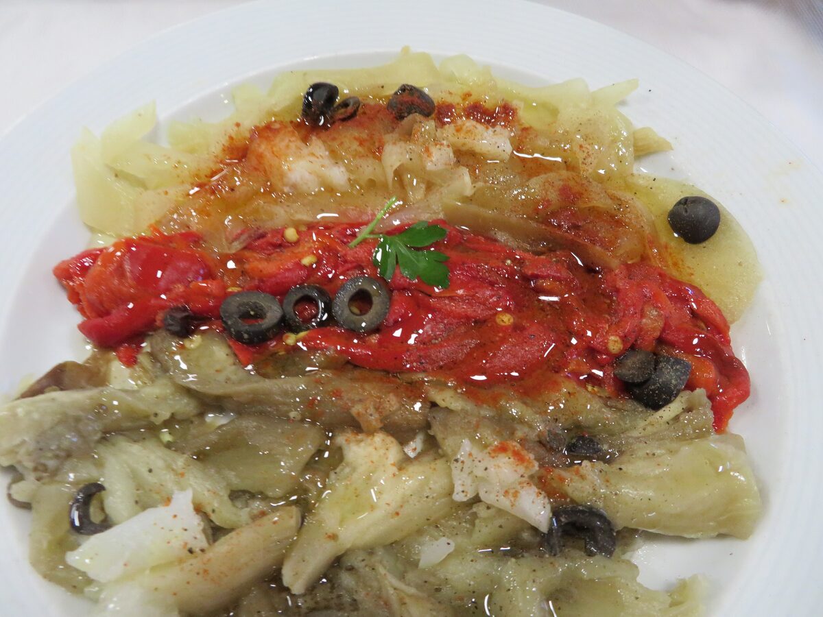 Roasted red pepper and aubergine with olives on a white plate