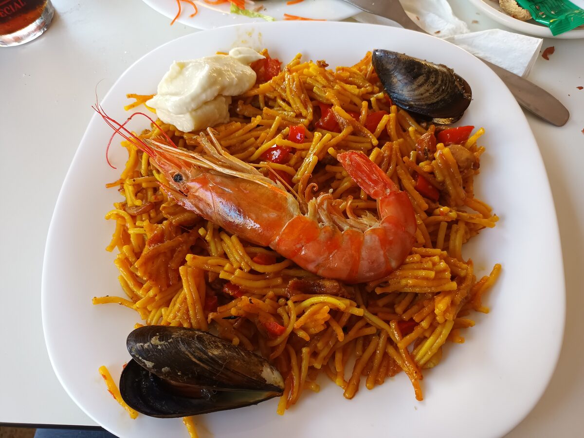 Fideuà with prawns and mussels on a white plate