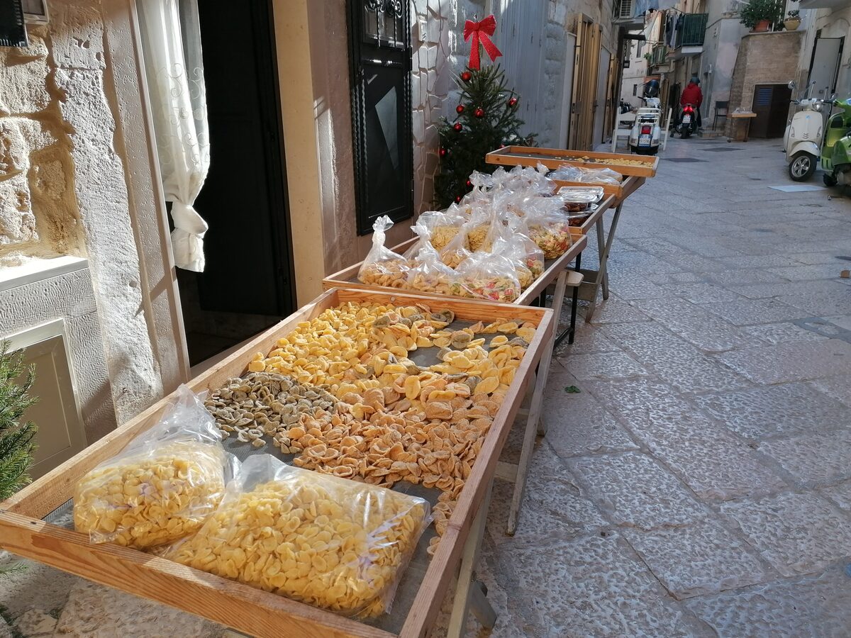 Wooden trays of orecchiette drying on a stall in a lane of Bari Vecchia